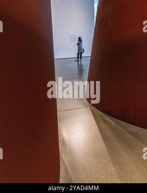 Los Angeles, CA, USA – 12 settembre 2024: Un visitatore legge un cartello per la scultura Band dell'artista Richard Serra al LA County Museum of Art di Foto Stock