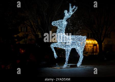 Renna decorata con luci natalizie su una strada della città di notte in Ungheria Foto Stock