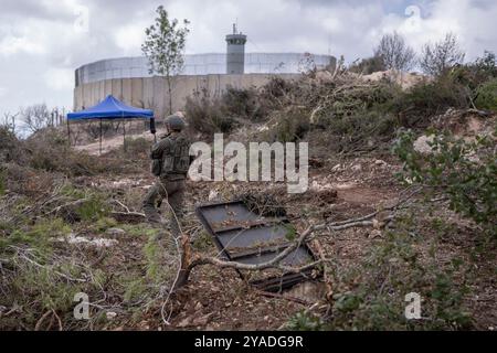 ATTENZIONE: LA PUBBLICAZIONE È VIETATA FINO AL 13 OTTOBRE ALLE 18:00 CET! - 13 ottobre 2024, Libano, Naqoura: Una fotografia, scattata durante un'incorporazione con le forze di difesa israeliane (IDF) e rivista dall'ufficio di censura IDF prima della pubblicazione, mostra un soldato israeliano che cammina accanto a un ingresso di tunnel vicino a un posto di osservazione delle forze interinali delle Nazioni Unite in Libano (UNIFIL), nel villaggio libanese meridionale di Naqoura lungo il confine con Israele. Foto: Ilia Yefimovich/dpa Foto Stock