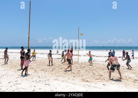 La gente del posto gioca a pallavolo contro i turisti a Diani Beach, nel distretto di Galu, Mombasa, Kenya Foto Stock