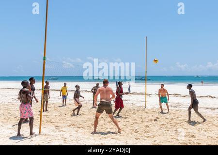 La gente del posto gioca a pallavolo contro i turisti a Diani Beach, nel distretto di Galu, Mombasa, Kenya Foto Stock