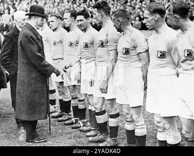 Re Giorgio V stringe la mano alla squadra del Manchester City in vista della finale della Coppa del 1926, Wembley Stadium, Londra. I giocatori, i funzionari delle partite e i presidenti dei club furono presentati a King George V (1865-1936), prima della finale di Coppa del 1926, in cui il Bolton Wanderers batté il Manchester City per 1-0. Foto Stock