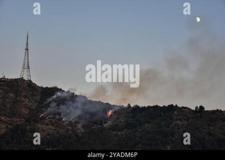 Srinagar, India. 13 ottobre 2024. Fiamme e fumo sorgono dalle colline di Zabarwan durante un incendio boschivo a seguito delle condizioni meteorologiche secche di Srinagar, la capitale estiva del Jammu e del Kashmir. (Immagine di credito: © Saqib Majeed/SOPA Images via ZUMA Press Wire) SOLO PER USO EDITORIALE! Non per USO commerciale! Crediti: ZUMA Press, Inc./Alamy Live News Foto Stock