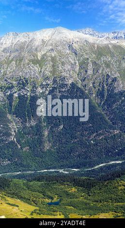 Vista del fiume che scorre fuori da un ghiacciaio di montagna, scenario delle montagne Dombay, Karachay-Cherkessia Repubblica di Russia Foto Stock