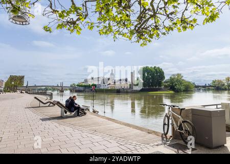 Chalon-sur-Saone, Francia - 30 aprile 2024: Viale lungo il fiume Saone con vista sull'isola di Saint-Laurent e il nostro du Doyenne a Chalon-sur-Saone, nella regione francese della Borgogna Foto Stock