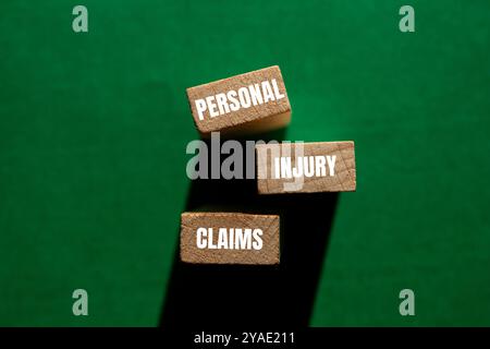 Messaggio relativo alle richieste di risarcimento lesioni personali scritto su blocchi di legno con sfondo verde. Simbolo delle richieste di risarcimento per lesioni personali concettuali. Copia spazio. Foto Stock