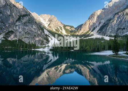 Riflessioni pomeridiane al Pragser Wildsee, Dolomiti, con cime rocciose e foreste di pini in estate Foto Stock