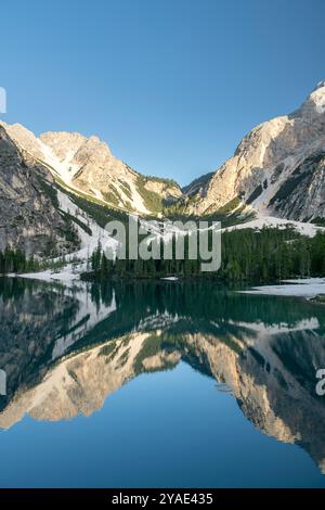 Riflessioni pomeridiane al Pragser Wildsee, Dolomiti, con cime rocciose e foreste di pini in estate Foto Stock