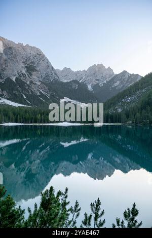 Riflessioni pomeridiane al Pragser Wildsee, Dolomiti, con cime rocciose e foreste di pini in estate Foto Stock