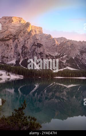 Serena serata estiva al Pragser Wildsee con maestose riflessioni sulle cime dolomitiche, lussureggianti pinete e il Lago di Smeraldo, in alto Adige Foto Stock