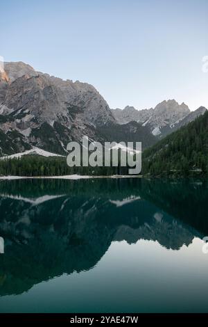 Riflessioni pomeridiane al Pragser Wildsee, Dolomiti, con cime rocciose e foreste di pini in estate Foto Stock