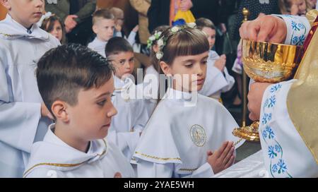 Lida, Bielorussia - 15 giugno 2021: I bambini ricevono la prima Santa comunione nella cerimonia della chiesa Foto Stock