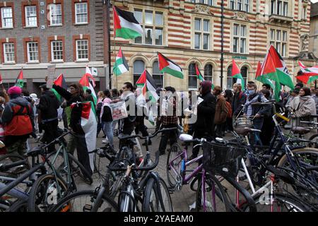 Cambridge, Inghilterra, Regno Unito. 13 ottobre 2024. Manifestanti, molti studenti universitari, marciano attraverso il centro della città portando bandiere e cantando. I manifestanti si radunano attraverso il centro di Cambridge chiedendo che l'università e il pubblico in generale cedano e boicottino le aziende che sostengono gli israeliani nella loro guerra contro Gaza, Libano e Cisgiordania. (Credit Image: © Martin Pope/ZUMA Press Wire) SOLO PER USO EDITORIALE! Non per USO commerciale! Foto Stock