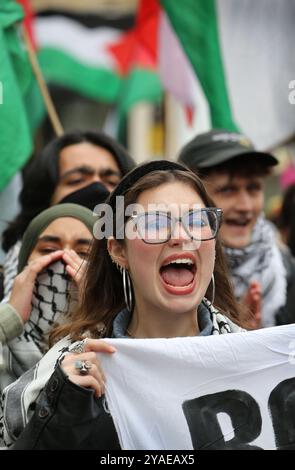 Cambridge, Inghilterra, Regno Unito. 13 ottobre 2024. Un manifestante grida e canti mentre marciano durante la manifestazione. I manifestanti si radunano attraverso il centro di Cambridge chiedendo che l'università e il pubblico in generale cedano e boicottino le aziende che sostengono gli israeliani nella loro guerra contro Gaza, Libano e Cisgiordania. (Credit Image: © Martin Pope/ZUMA Press Wire) SOLO PER USO EDITORIALE! Non per USO commerciale! Foto Stock