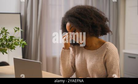 Ragazza afro-americana donna d'affari freelancer che lavora laptop a casa cucina finire lavoro lontano stanca donna d'affari chiudere notebook computer prendere Foto Stock