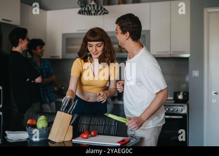 Amici che si godono una divertente sessione di cucina insieme in una cucina moderna Foto Stock