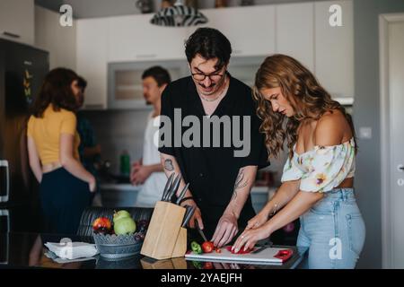 Amici che si godono una sessione di cucina informale in cucina Foto Stock