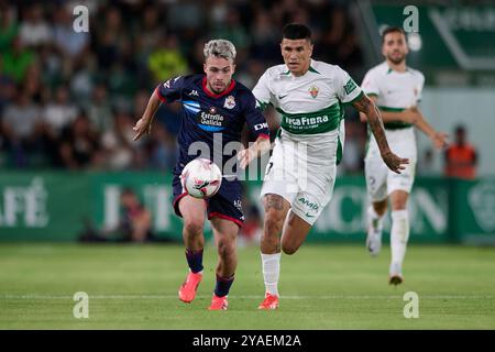 Elche, Spagna. 13 ottobre 2024. ELCHE, SPAGNA - 13 OTTOBRE: David Mella Right Winger RC Deportivo de la Coruna compete per il pallone con Nico Castro che attacca il centrocampo dell'Elche CF durante il LaLiga Hypermotion match tra Elche CF e RC Deportivo de la Coruna all'Estadio Manuel Martinez Valero il 13 ottobre 2024 a Elche, Spagna. (Foto di Francisco Macia/Photo Players Images/Magara Press) crediti: Magara Press SL/Alamy Live News Foto Stock