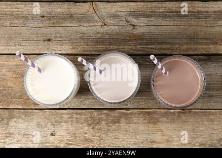 Diversi gustosi cocktail proteici in bicchieri su un tavolo di legno, piatto Foto Stock