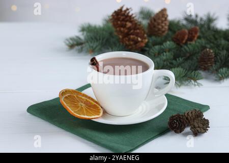 Ottimo cacao in tazza e rami di abete su un tavolo di legno bianco Foto Stock