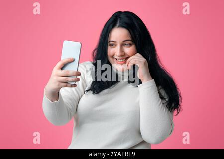 Pretty Pump Donna Che Prende Selfie Su Smartphone, Isolato Su Sfondo Rosa Foto Stock