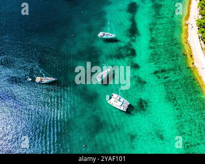 Vista dall'alto su barche a vela ancorate nelle splendide e cristalline acque di Rogoznica, Croazia, famosa destinazione nautica dell'adriatico Foto Stock