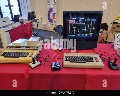 Vecchi, storici, computer Commodore d'epoca con monitor esposti su un tavolo rosso presso l'HCC Kennisdag di Expo Houten, Paesi Bassi Foto Stock