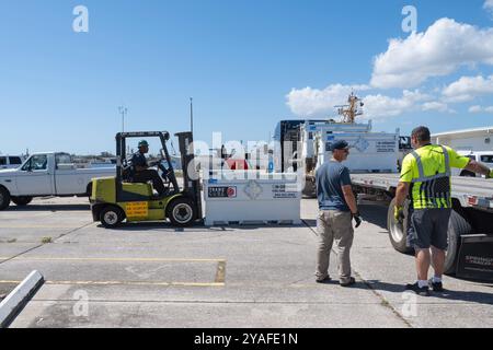 I membri della Guardia Costiera degli Stati Uniti scaricano i contenitori di combustibile presso il settore della Guardia Costiera di St. Petersburg, Florida, 13 ottobre 2024. Il carburante è destinato alle unità situate nel settore San Pietroburgo per continuare le operazioni. (Foto della Guardia Costiera degli Stati Uniti di Alejandro Rivera, sottufficiale di seconda classe) Foto Stock