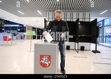 Vilnius, Lituania. 13 ottobre 2024. Un elettore lancia il suo voto in un seggio elettorale per le elezioni parlamentari a Vilnius, Lituania, 13 ottobre 2024. Il primo turno delle elezioni parlamentari lituane è iniziato domenica, con gli elettori destinati a eleggere 141 membri al Seimas, il parlamento unicamerale del paese, per un mandato di quattro anni. Secondo la Commissione elettorale centrale (VRK), 1.740 candidati sono in competizione alle elezioni. Crediti: Alfredas Pliadis/Xinhua/Alamy Live News Foto Stock