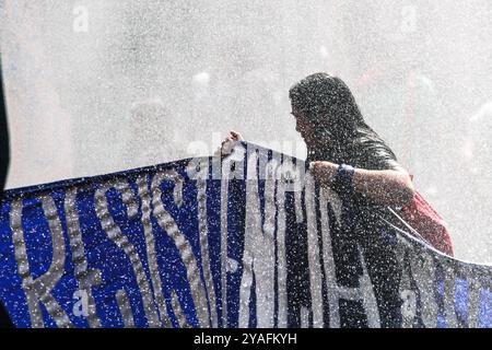 Santiago, Cile. 13 ottobre 2024. Un manifestante tiene uno striscione mentre viene spruzzato da un cannone d'acqua dalla polizia durante la marcia dimostrativa per la resistenza dei Mapuche e di tutti i popoli indigeni. A Santiago del Cile si svolge una marcia dimostrativa per la resistenza Mapuche e per tutte le popolazioni indigene, che riunisce decine di persone. Allo stesso tempo, si verificarono scontri con la polizia, con gas lacrimogeni, spray al pepe e cannoni ad acqua utilizzati. (Foto di Cristobal Basaure Araya/SOPA Images/Sipa USA) credito: SIPA USA/Alamy Live News Foto Stock