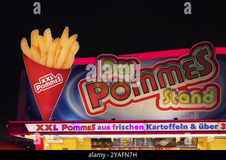 Night shot, stalle, patatine fritte, pubblicità, illuminazione al neon, Cannstatter Wasen, festival popolare, Blue Hour, Bad Cannstatt, Stoccarda, Baden-Wuerttembe Foto Stock