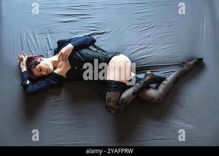 Vista dall'alto di una donna di 23 anni sdraiata su un letto blu, Bruxelles, Belgio, Europa Foto Stock