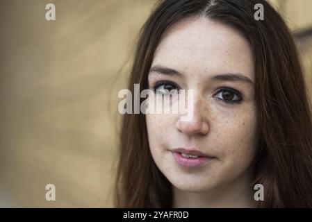 Ritratto alla moda di una ragazza dai capelli rossi di 18 anni in piedi contro un muro Foto Stock