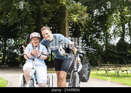 Hakendover, Brabante fiammingo, Belgio, 09 20 2021: Donna di 39 anni con sindrome di Down e suo fratello felice in bicicletta, Europa Foto Stock