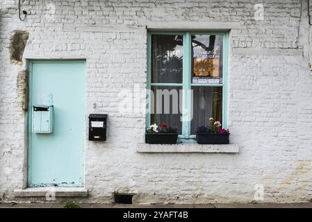 Uccle, Bruxelles, Belgio, 06 14 2019, facciata d'epoca di una casa contadina in pietra di mattoni con una finestra verde nel parco Fond' Roy, Europa Foto Stock