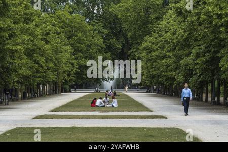 Centro città di Bruxelles, regione di Bruxelles capitale, Belgio, 06 20 2020 famiglia marocchina che ha un picnic e un uomo d'affari durante la pausa pranzo alla pari Foto Stock