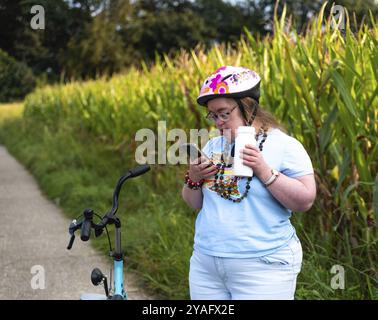 Hakendover, Brabante fiammingo, Belgio, 09 20 2021: Donna di 39 anni con sindrome di Down che chiama suo fratello su uno smartphone, Europa Foto Stock