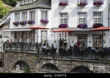 Centro storico di Monschau, Renania settentrionale-Vestfalia, Germania, 08 27 2019 turisti seduti su terrazze soleggiate sulle rive del fiume Ruhr, Europa Foto Stock