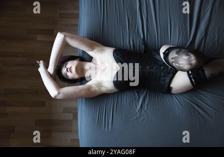 Vista dall'alto di una donna di 23 anni sdraiata su un letto blu, Bruxelles, Belgio, Europa Foto Stock