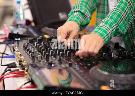 Primo piano di un DJ che mixa musica su una console di mixaggio. Messa a fuoco selettiva. Foto Stock