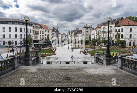 Ixelles, Bruxelles, Belgio, 05 31 2019, giovane ragazzo e madre che suonano alla fontana di fronte al municipio in piazza Fernand Cocq, Europa Foto Stock