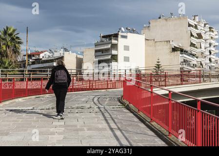 Freattyda, Atene, Grecia, 12 28 2019 escursione turistica a piedi su un ponte pedonale rosso presso il centro dei trasporti Olympiakos, Europa Foto Stock