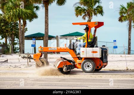 Bonita Beach, Florida, USA - 11 ottobre 2024: Uomo che spazza la sabbia dalle strade dopo l'uragano Milton Foto Stock