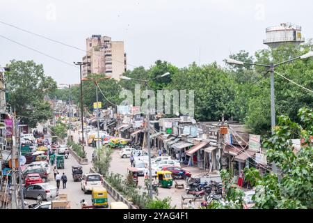 Vivace strada a delhi, india, che mostra la bellezza caotica della vita quotidiana con il suo vibrante mix di negozi, veicoli e persone Foto Stock