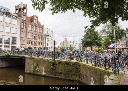 Un piccolo parco ciclabile raffigurato accanto e sopra un ponte sul canale Singel ad Amsterdam, Paesi Bassi, visto il 26 maggio 2024. Foto Stock