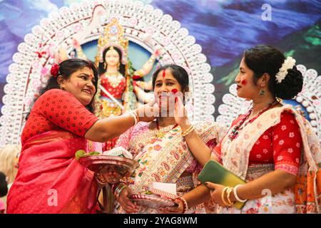 Durga Puja festival a Dacca i devoti prendono parte a un rituale Sindoor Khela in cui le donne sposate si uniscono a vicenda con polvere di vermiglio prima dell'immersione della dea indù Durga idoli durante la festa indù di Durga Puja a Dacca il 13 ottobre 2024. Dhaka Distretto di Dhaka Bangladesh Copyright: XHabiburxRahmanx Foto Stock