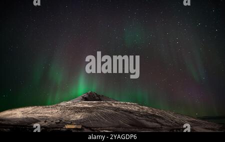 Aurora Australis (luci del Sud) in mostra sull'isola di Ross, in Antartide, con Observation Hill in primo piano Foto Stock