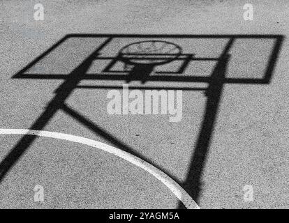 Shadow of the Basketball Board: Tempo di gioco astratto nel cortile all'aperto. Foto Stock