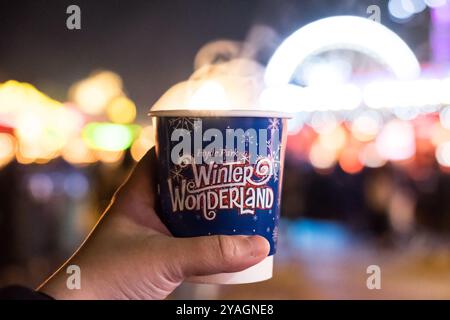 Londra, Regno Unito - 17 novembre 2017: Mano che regge una tazza di VIN brulé con sfondo sfocato di Winter Wonderland, un mercatino di Natale a Hyde Foto Stock