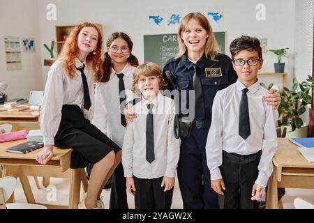 Agente di polizia e gruppo di adolescenti in classe Foto Stock